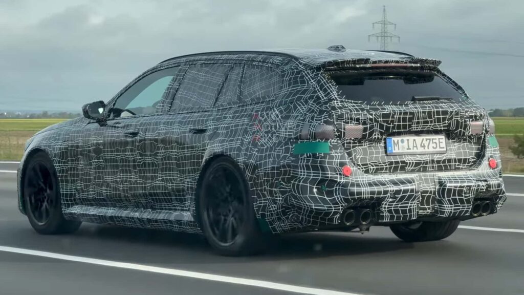 Une BMW M5 Touring Wagon espionnée sur une autoroute de croisière entièrement habillée de camouflage