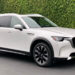 2024 Mazda CX-90 PHEV in white with a green backdrop.