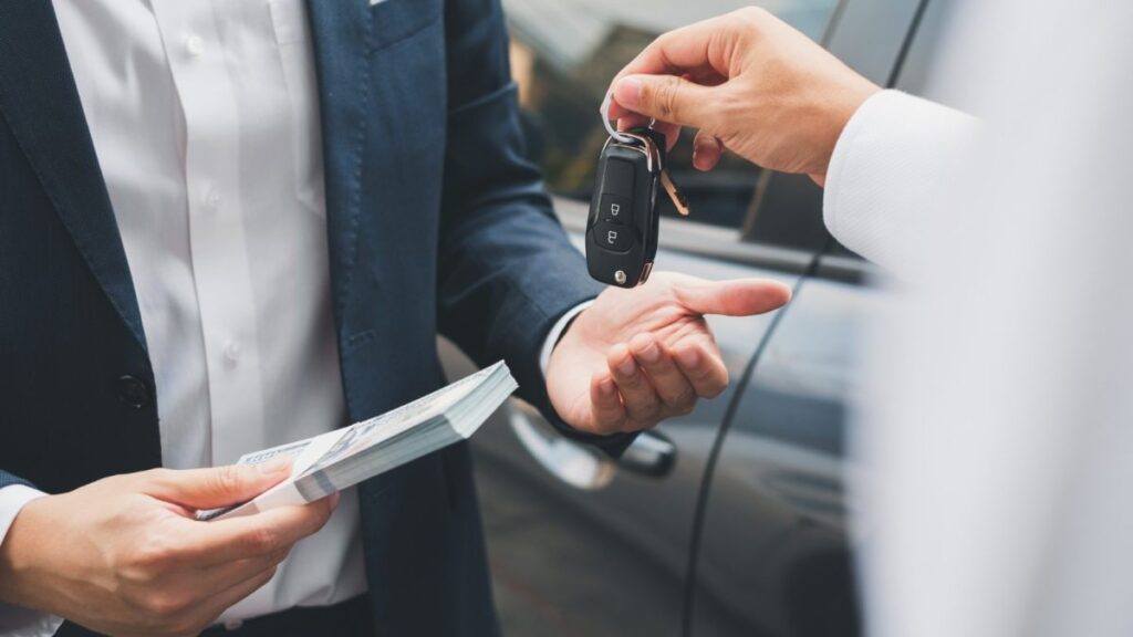 Giving a car key in exchange for cash to buy a car